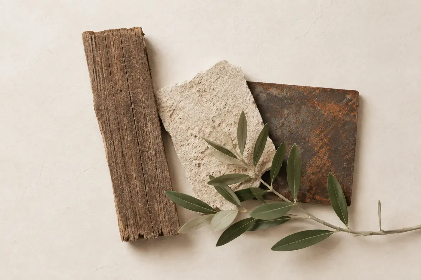 Échantillons de bois, pierre locale, acier patiné et branche d’olivier